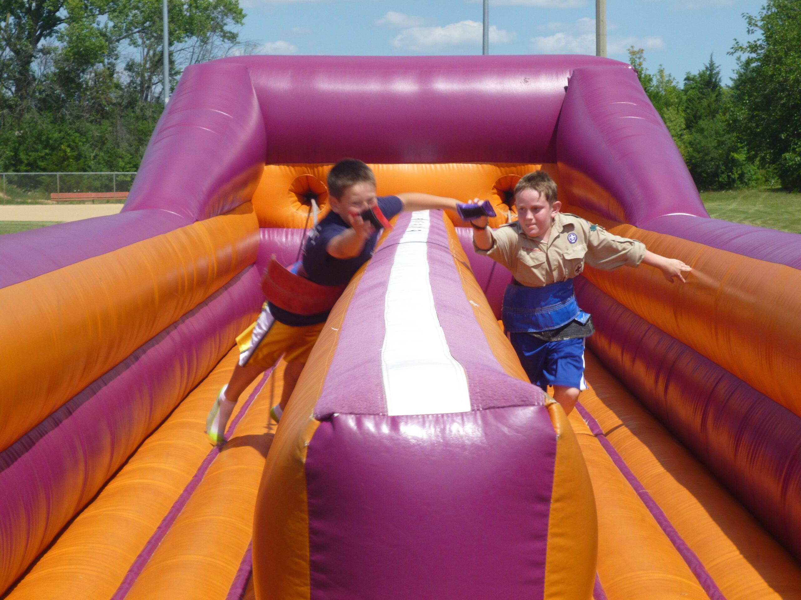 Two kids racing through an inflatable course
